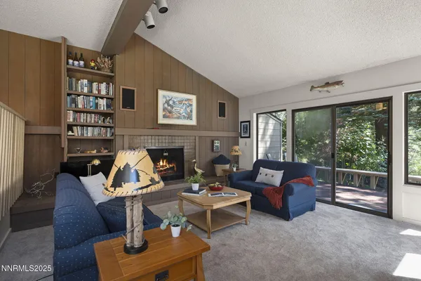 a living room with furniture a fireplace and a large window