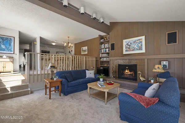 a living room with furniture a fireplace and a large window