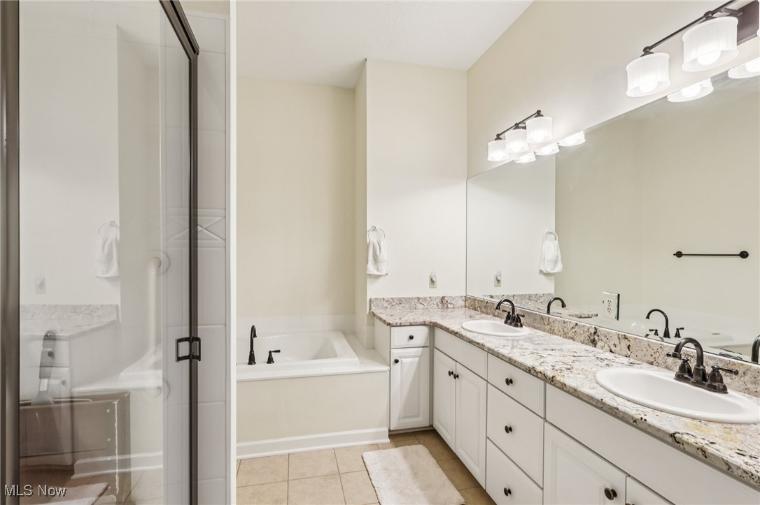249 Granger Road, Unit 87 Medina, OH 44256 - Photo 21 of 38 Full bath featuring double vanity, a bath, a shower stall, and tile floors