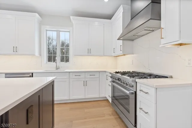 a large kitchen with stainless steel appliances kitchen island a large counter tops a stove a sink and a refrigerator