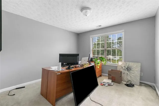 a view of a workspace with furniture and a window