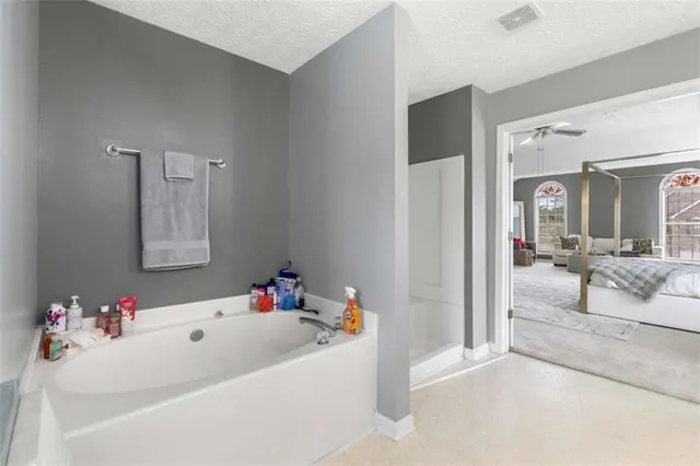 a bathroom with a tub sink and mirror
