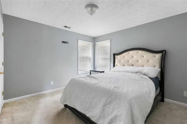 a large bed sitting in a bedroom next to a window