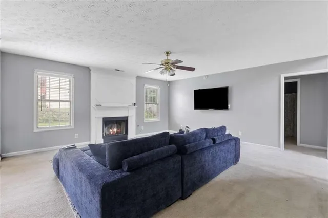 a living room with furniture a fireplace and a flat screen tv