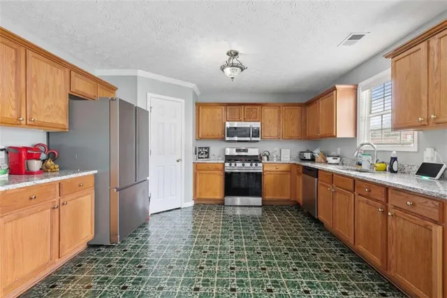 a kitchen with stainless steel appliances granite countertop a refrigerator sink and cabinets