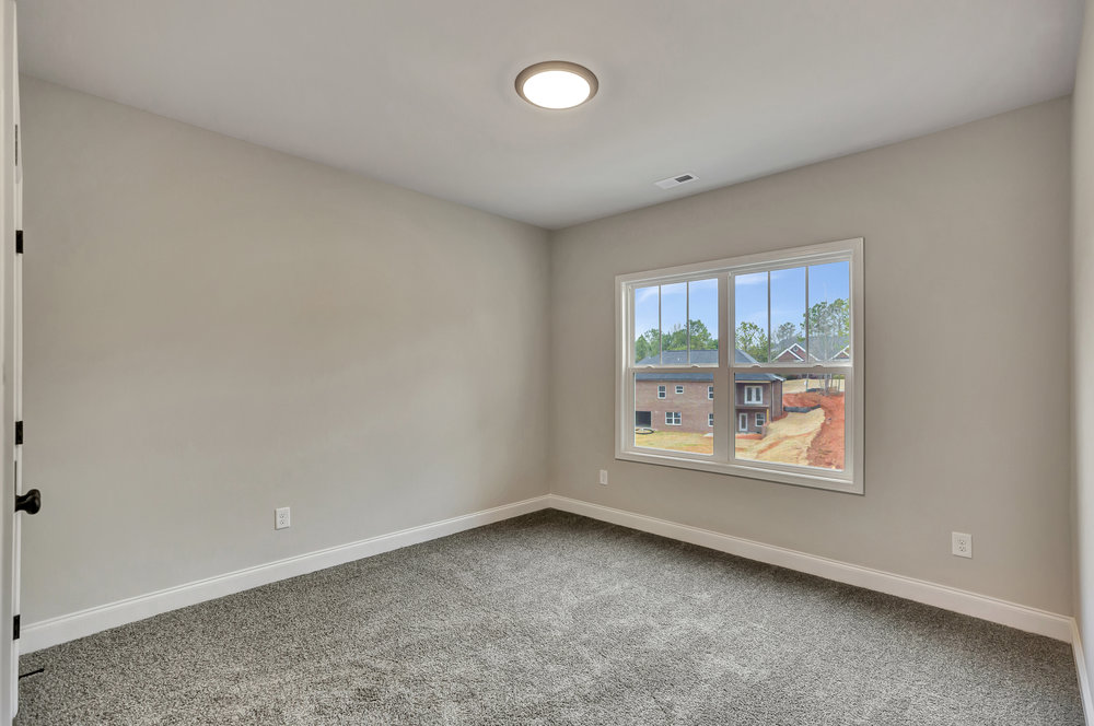 118 Bonaire Point Anderson, SC 29621 - Photo 18 of 23 This inviting bedroom features soft carpeting and a bright window, creating a serene and comfortable living space.