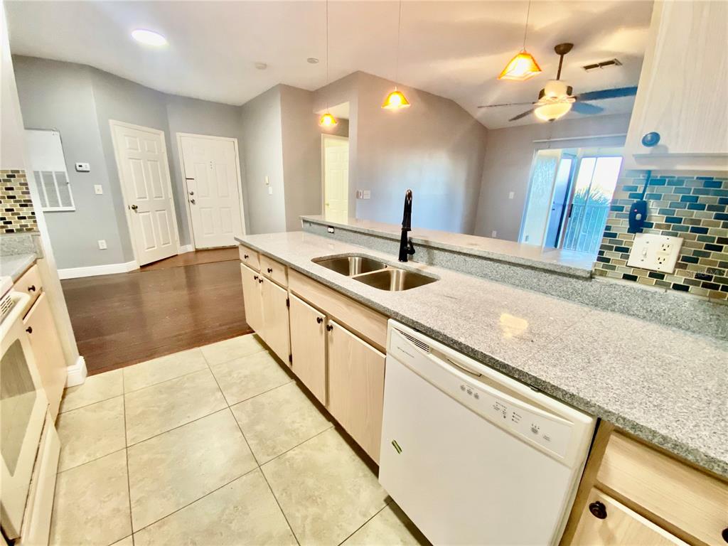 5451 Vineland Road, Unit 2309 Orlando, FL 32811 - Photo 12 of 38 a large kitchen with kitchen island granite countertop a sink and a stove