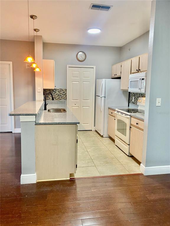 5451 Vineland Road, Unit 2309 Orlando, FL 32811 - Photo 16 of 38 a kitchen with a stove a sink and a refrigerator