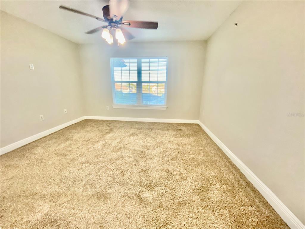 5451 Vineland Road, Unit 2309 Orlando, FL 32811 - Photo 18 of 38 an empty room with a window and ceiling fan