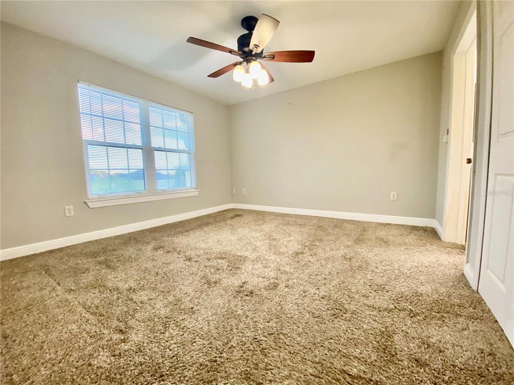 5451 Vineland Road, Unit 2309 Orlando, FL 32811 - Photo 22 of 38 an empty room with chandelier fan and windows