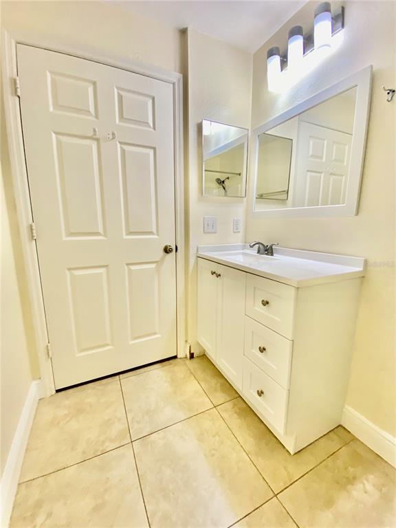 5451 Vineland Road, Unit 2309 Orlando, FL 32811 - Photo 33 of 38 a bathroom with a sink a mirror and a shower