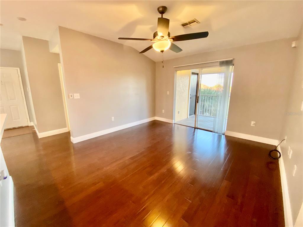 5451 Vineland Road, Unit 2309 Orlando, FL 32811 - Photo 37 of 38 an empty room with wooden floor fan and windows