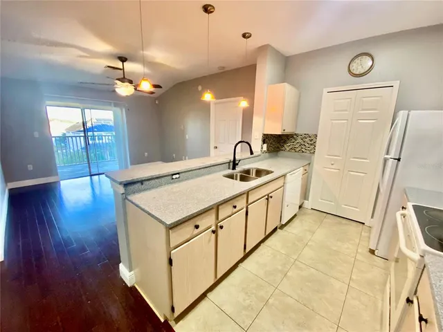 a kitchen with a stove a sink a refrigerator and a dining table