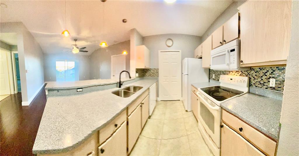 5451 Vineland Road, Unit 2309 Orlando, FL 32811 - Photo 8 of 38 a kitchen with a stove a sink a refrigerator and a dining table