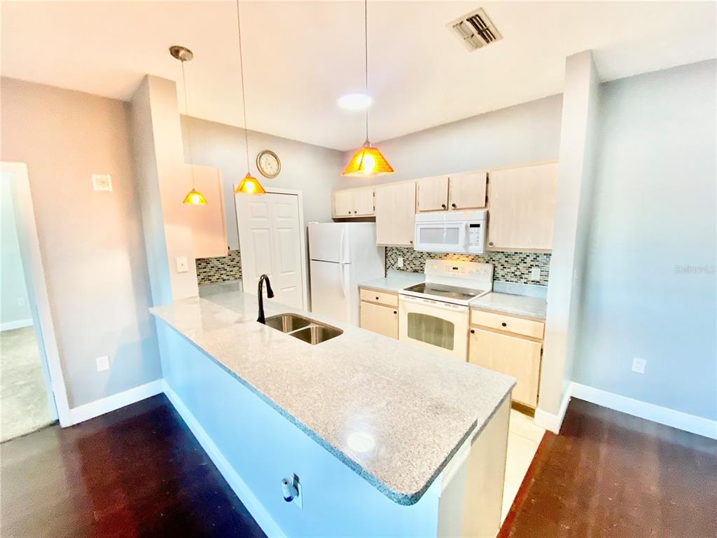 5451 Vineland Road, Unit 2309 Orlando, FL 32811 - Photo 9 of 38 a kitchen with a sink cabinets and wooden floor