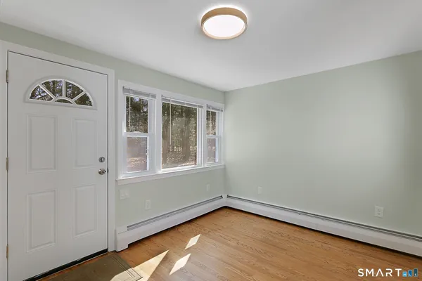 an empty room with wooden floor and windows