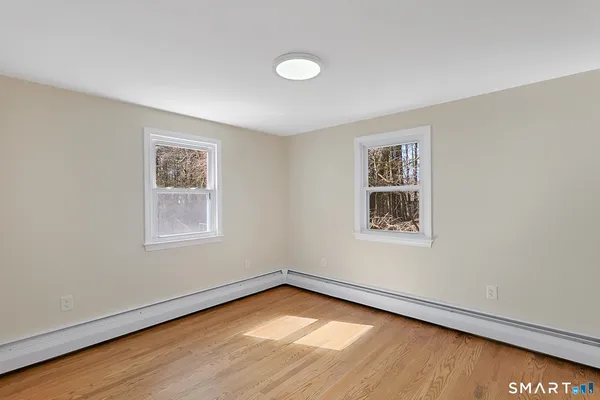 a view of an empty room with wooden floor