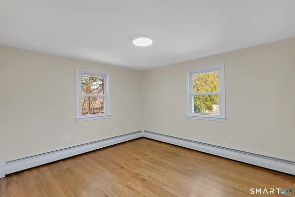 a view of an empty room with wooden floor