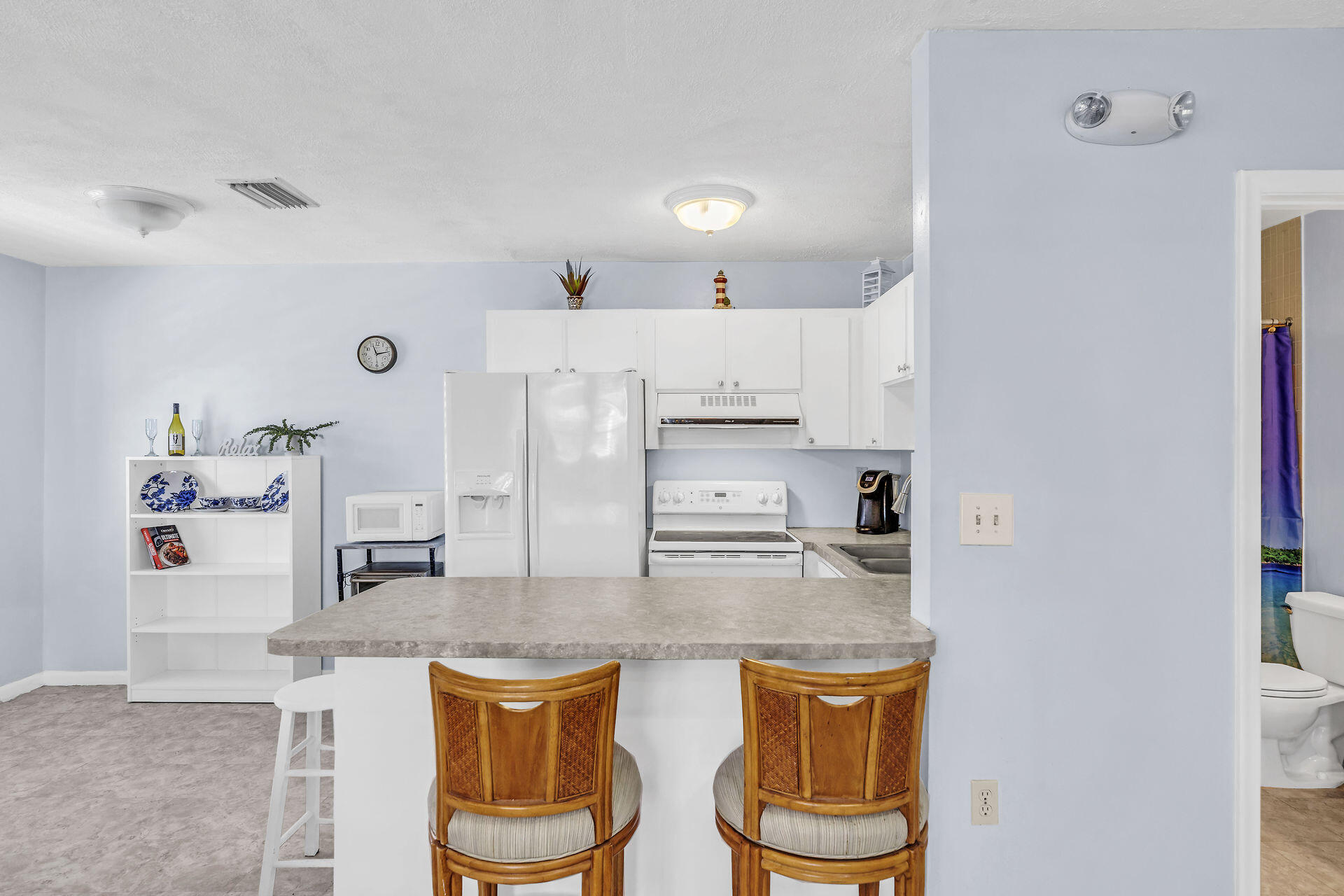 106 Channel Drive, Unit B Marathon, FL 33050 - Photo 18 of 33 a kitchen with stainless steel appliances granite countertop a kitchen island a stove a refrigerator and a dining table with wooden floor