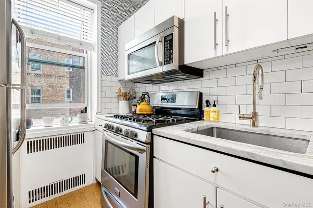 a kitchen with stainless steel appliances granite countertop a sink and a stove