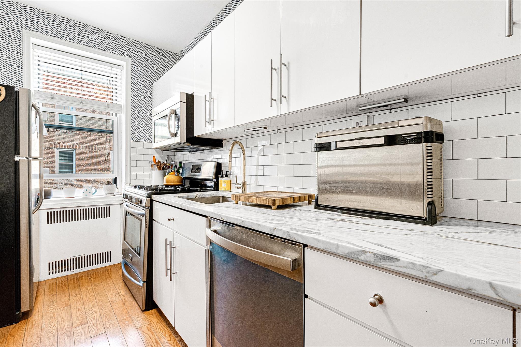 99-45 67th Road, Unit 514 Queens, NY 11375 - Photo 16 of 22 a kitchen with stainless steel appliances granite countertop a sink and a stove