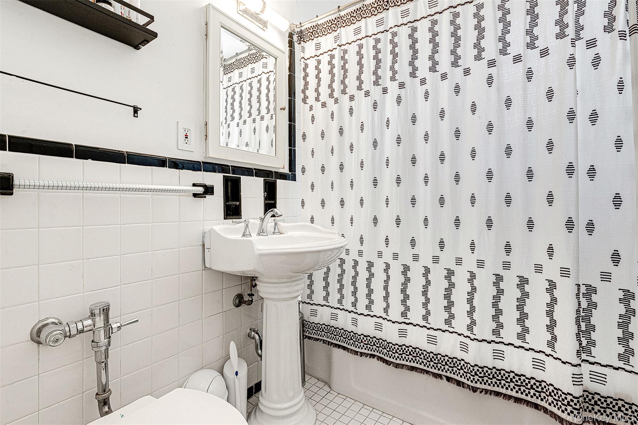 99-45 67th Road, Unit 514 Queens, NY 11375 - Photo 21 of 22 a bathroom with a sink toilet and mirror