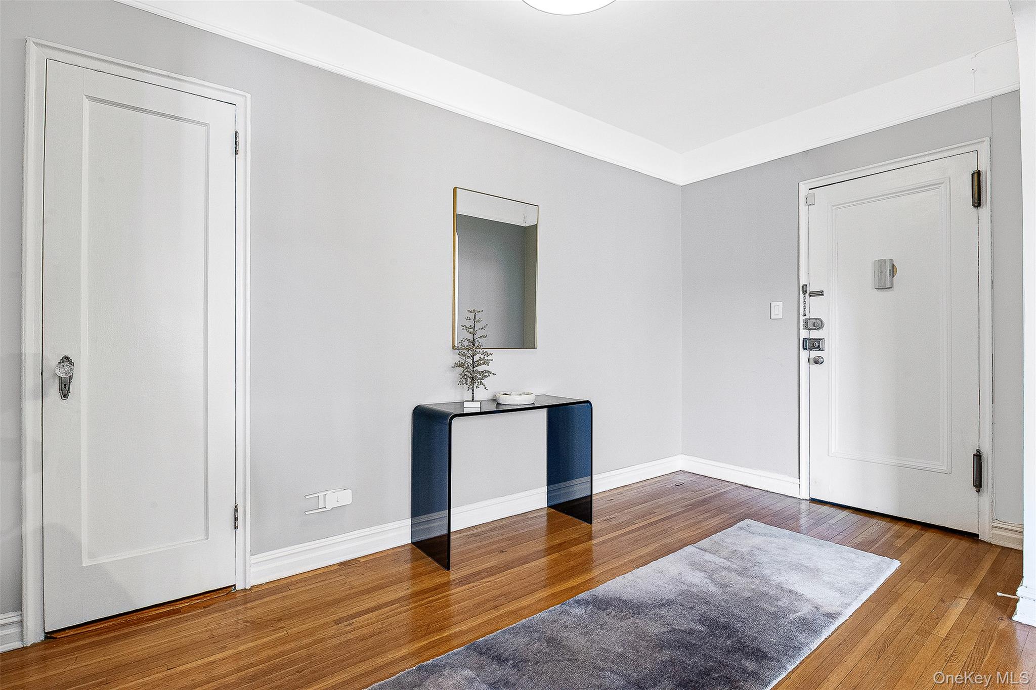 99-45 67th Road, Unit 514 Queens, NY 11375 - Photo 3 of 22 a view of a room with wooden floor and cabinet