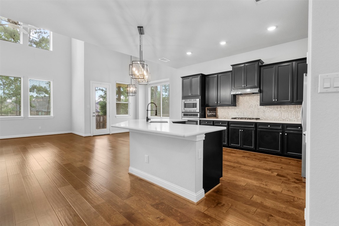 148 Gray Pne Grove Conroe, TX 77318 - Photo 13 of 46 a large kitchen with stainless steel appliances kitchen island granite countertop a stove a sink a refrigerator and a microwave