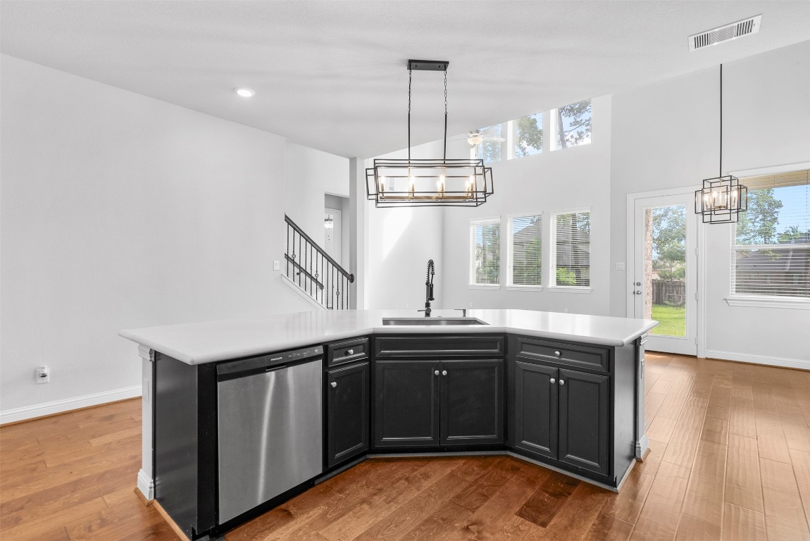 148 Gray Pne Grove Conroe, TX 77318 - Photo 27 of 46 a kitchen with stainless steel appliances granite countertop a sink dishwasher a stove and a dining table with wooden floor