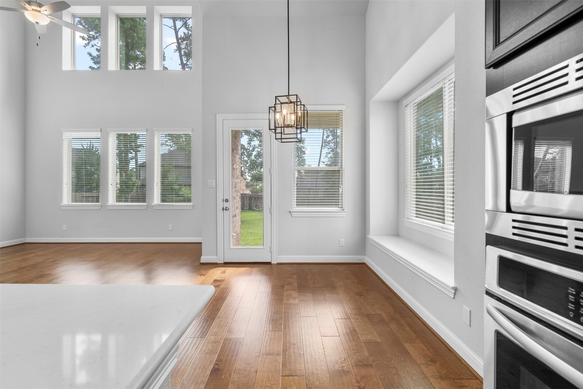 148 Gray Pne Grove Conroe, TX 77318 - Photo 28 of 46 a view of a hallway with wooden floor and a kitchen
