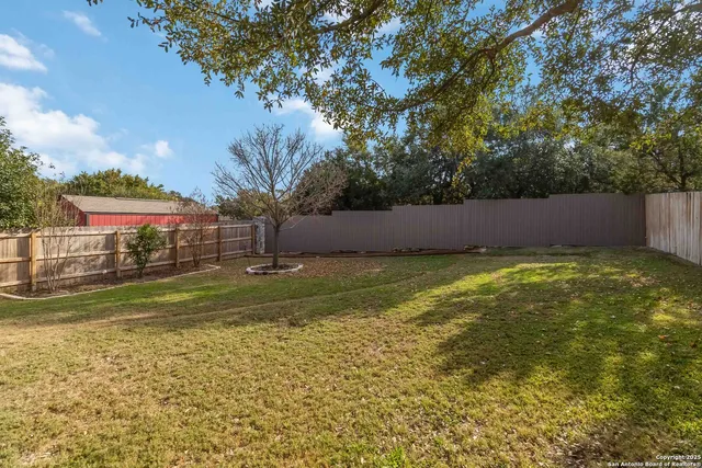 an outdoor sitting area with blue trees in front of it