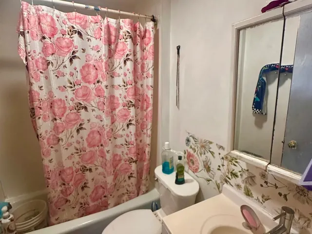 a bathroom with a granite countertop sink mirror vanity and toilet