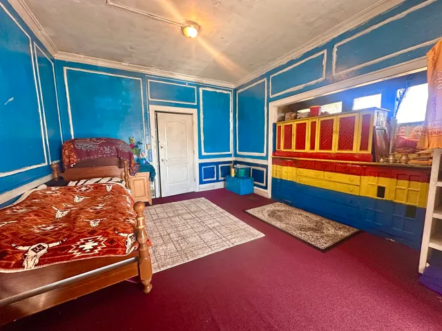 a bedroom with bed and wooden floor