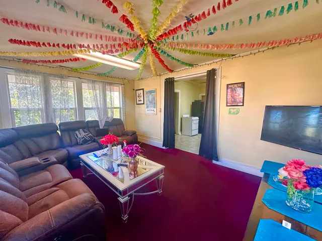 a living room with furniture and a dining table