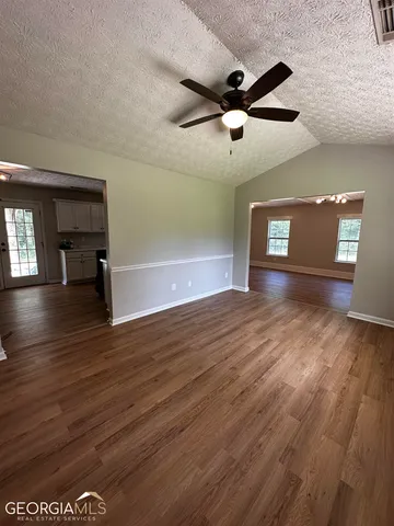 a view of empty room with wooden floor