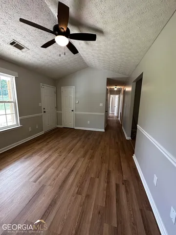 a view of empty room with wooden floor