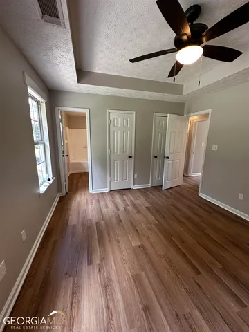 a view of empty room with wooden floor