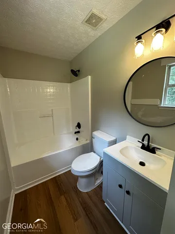 a bathroom with a sink a toilet and a mirror