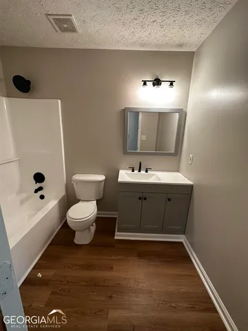 a bathroom with a sink a toilet and mirror