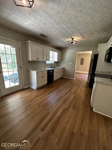 a view of a kitchen with wooden floor and electronic appliances