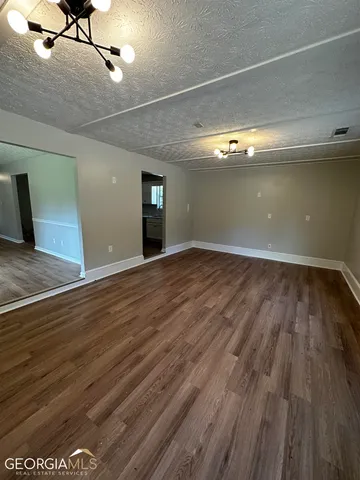 a view of an empty room with wooden floor