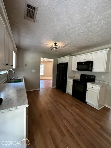a view of kitchen with sink microwave and refrigerator