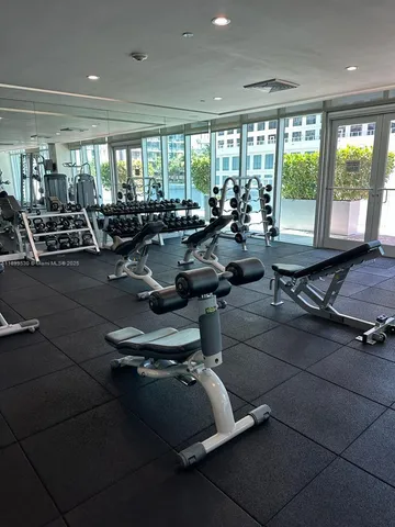 a room with gym equipment and large windows