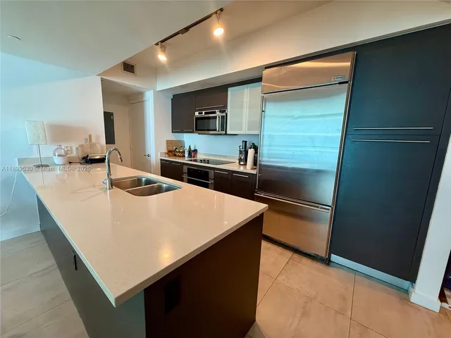 a kitchen with kitchen island a sink appliances and cabinets