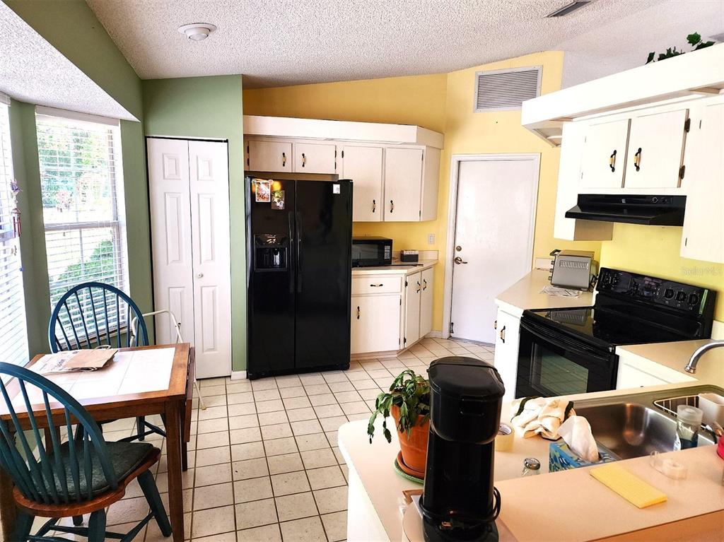 11660 Southwest 89th Terrace Ocala, FL 34481 - Photo 6 of 16 a kitchen with stainless steel appliances kitchen island granite countertop a refrigerator and a stove top oven