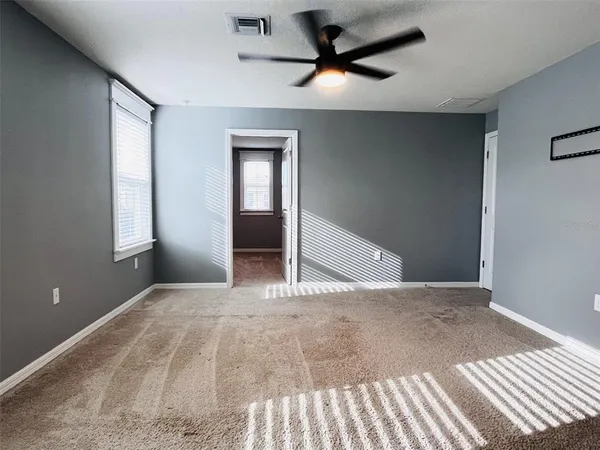 a view of a livingroom with a ceiling fan and window