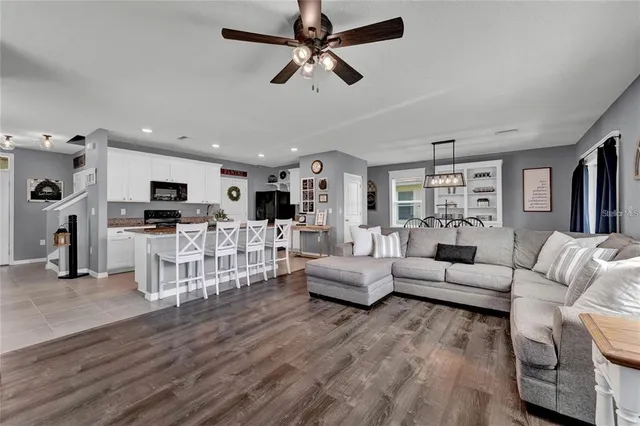 a living room with furniture and view of kitchen