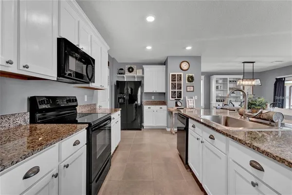 a large kitchen with stainless steel appliances granite countertop a lot of counter space and a sink