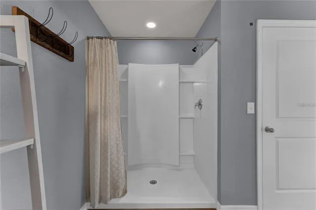 a bathroom with a shower and a glass door