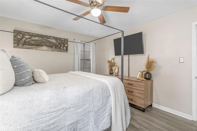 a bedroom with a bed dresser and wooden floor